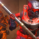 Two spartans in Halo Infinite, one red and one orange, with the red one holding the flag.